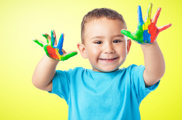 portrait of cute kid having fun with hands paint