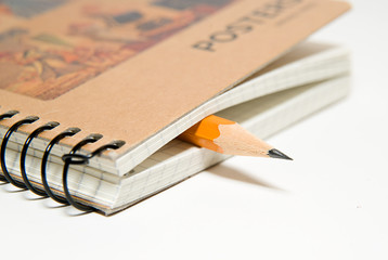 Opened notebook and pencil on over white