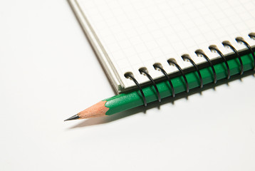Opened notebook and pencil on over white