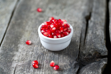 pomegranate seeds on wooden surface