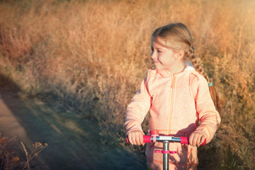 Beautiful girl driving scooter on rural road