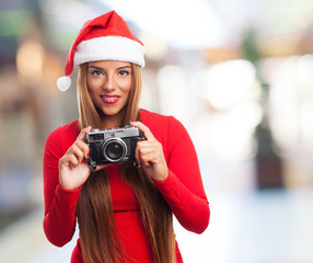 portrait of a beautiful young woman at Christmas taking a photo with her camera