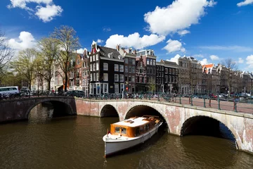 Foto auf Alu-Dibond Amsterdam canal intersection with white boat in summer with a blue sky © dennisvdwater