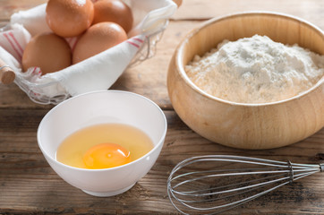 Eggs and flour on wood table.