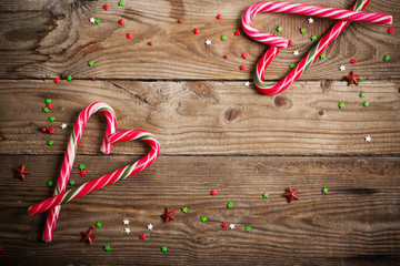 candy canes as heart on  wooden board - Powered by Adobe
