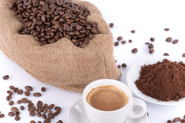 Cup of coffee with coffee beans and powder