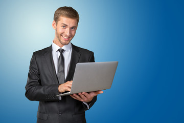 Young handsome businessman holding laptop