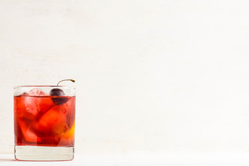 Old fashioned cocktail on white wooden background