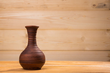 Ceramic bottle on wooden background.