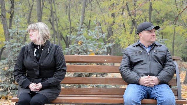 Man and woman looking in different directions while sitting on the bench