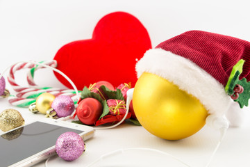 Christmas ball with Santa's hat and earphones with ornaments on white