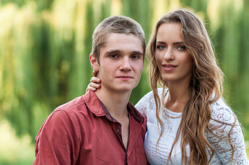 Fototapeta premium Portrait of a young couple against green park