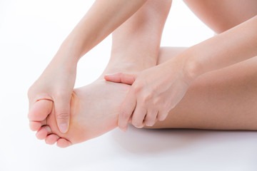 足裏をマッサージする若い女性