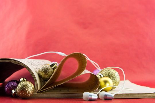 Music Notation Book With Pages Shaping Heart With Earphones And Christmas Ornaments