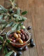 Fresh olives and olive branch on wood background