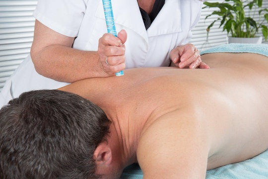  Therapist in chinese medicine working on the back of a  man