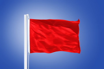 Red flag flying against clear blue sky