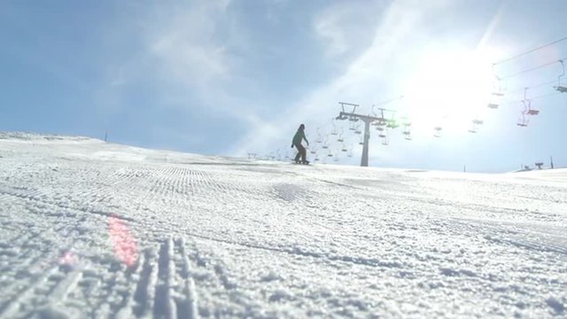 SLOW MOTION: Race snowboarder carving down the icy ski slope 