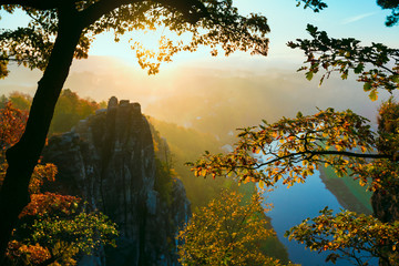 View into deep misty valley in Saxon Switzerland. Sandstone peak