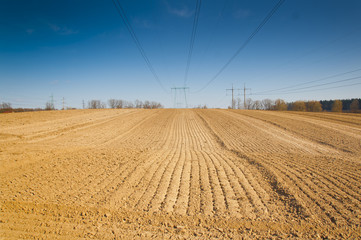spring plowed field, over the field of high-voltage power line