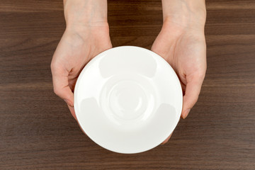 Fototapeta na wymiar Womans hands holding saucer