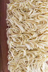 egg noodles spiral closeup on wooden background