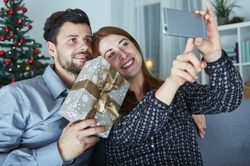 happy couple is taking a selfie with gift
