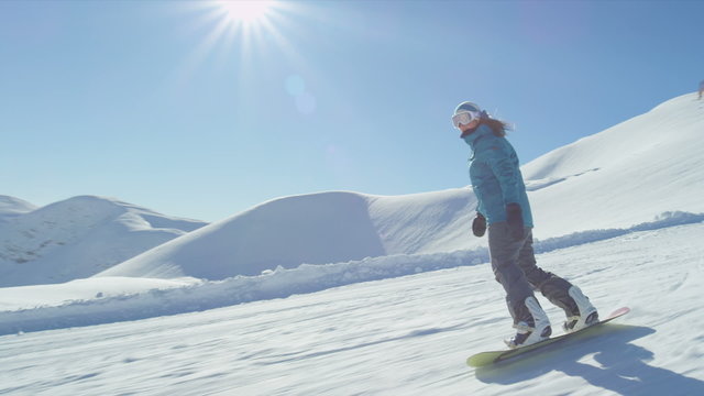 SLOW MOTION: Girl snowboarding on a sunny day