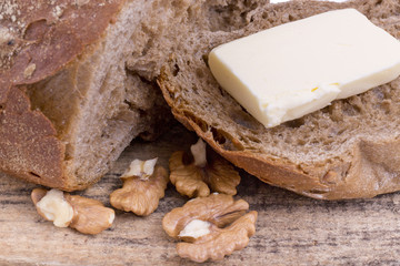 fresh rye bread with walnuts on wooden background