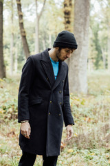 young man with black hat in forest