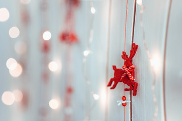 new year's and christmas decoration of a red deer hanging on a wooden texture wall with lights