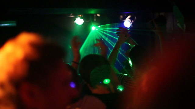 Laser lights and crowds at DJ show in club