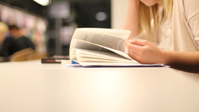 Female student flipping through book pages