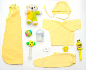 top view of baby girl yellow clothes and toy stuff