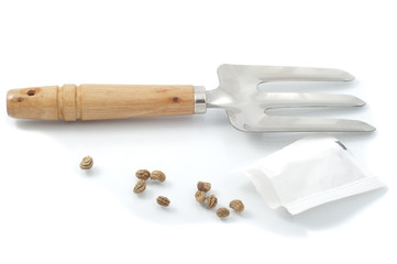 nasturtium seeds and garden rakes closeup on white background