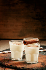Traditional winter eggnog  with milk, rum and cinnamon, sprinkle