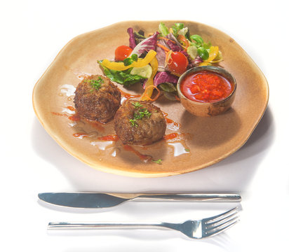 Meat cutles with tomato sauce and vegetables isolated on white