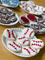 cookies on plates decorated as baseballs, basketballs and American footballs