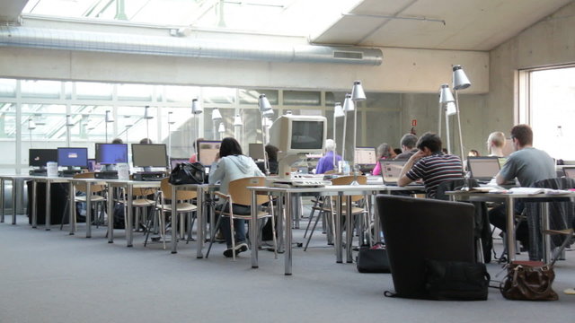 Students and laptop at university library