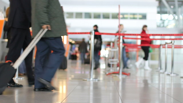 People at airport ticket office and line