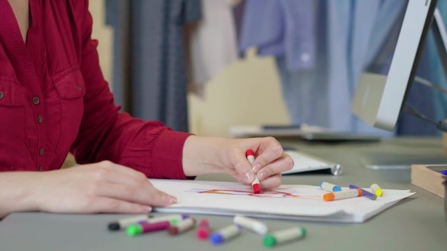 modedesignerin zeichnet einen entwurf f&uuml;r ein kleid