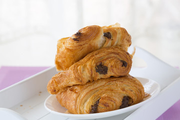 croissants with chocolate filling on a white plate on a white tray. breakfast. French pastries. side and top view, high key.