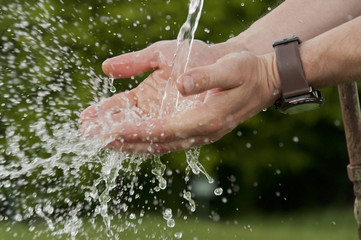 Fototapeta premium men's hands under running cold water