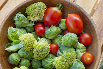 cherry tomatoes, brussels sprouts with broccoli on a wooden tabl