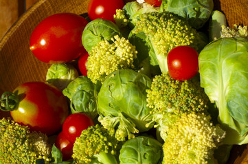 cherry tomatoes and brussels sprouts and broccoli on wooden plat