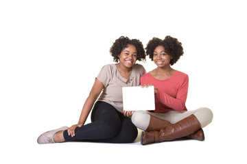 Sisters or friends using a computer isolated on white