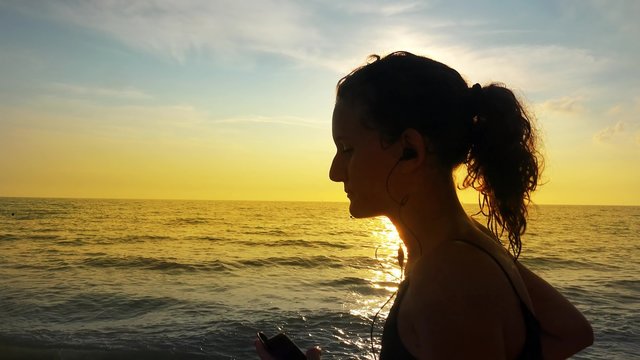 Running fit girl with horsetail and earphones 