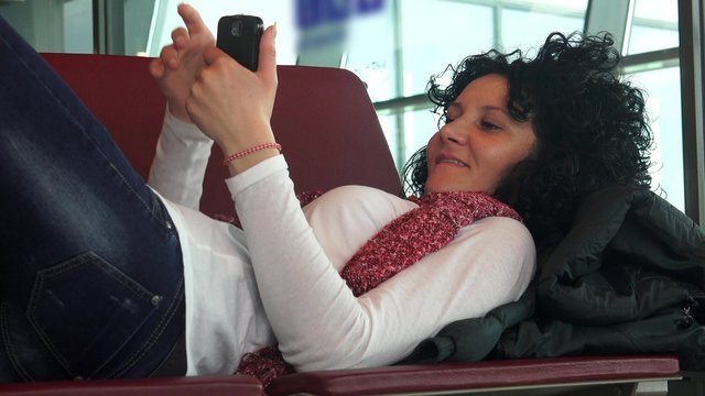 Happy teen surfing internet on smartphone lying 