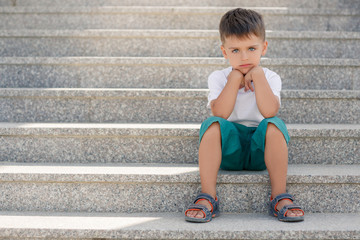 The boy sitting on the stairs in the underpass