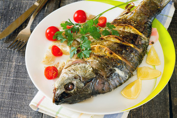 Baked fish (carp) with onion and lemon in a rustic style